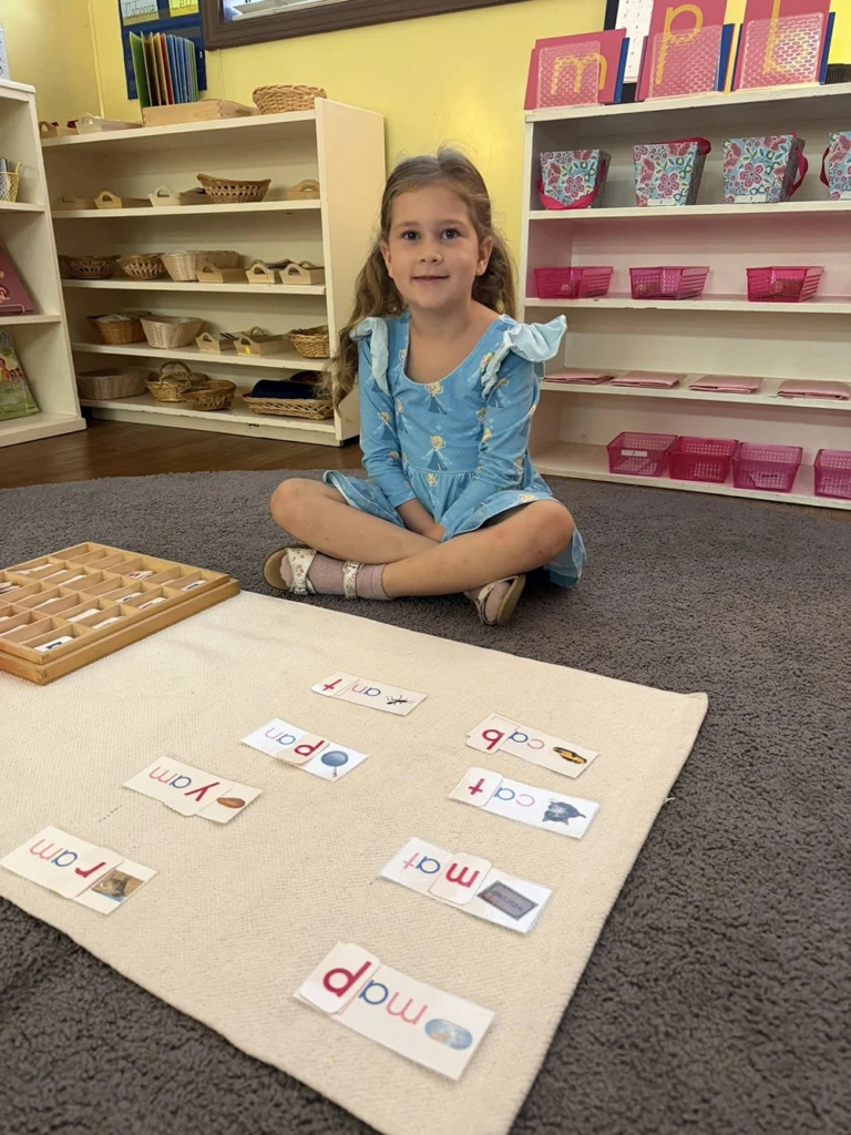 Child sitting with phonics cards during a Montessori language lesson