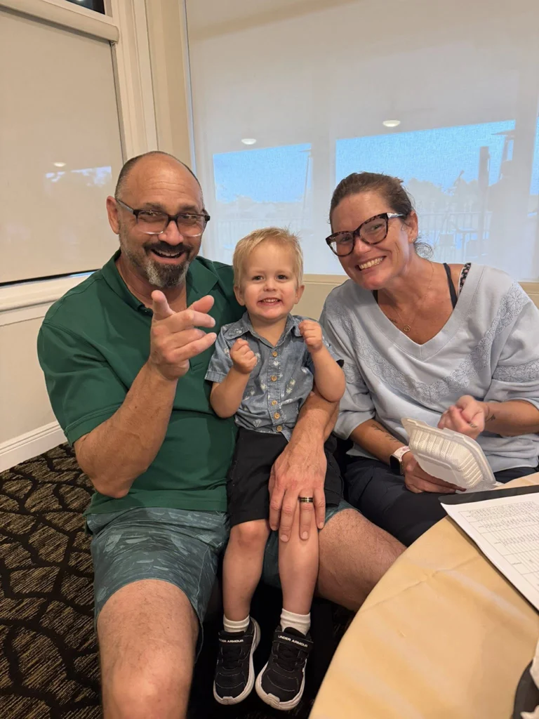 Young child sitting with parents during a Countryside Montessori Academy classroom event.