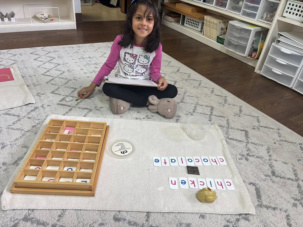 Child working with letter cards to spell words on a classroom mat