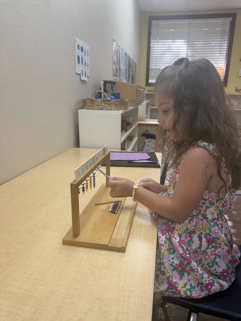 Child using a Montessori bead frame during a math lesson