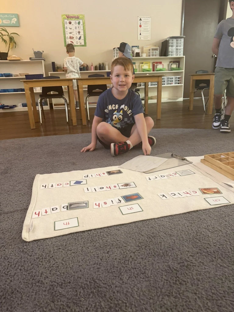 Child working with phonics cards and word-building materials in the classroom