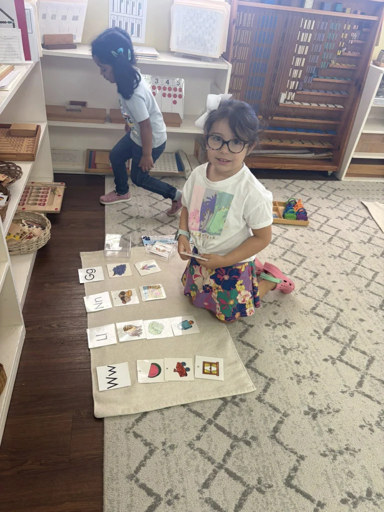 Child matching picture cards to letter sounds during a classroom lesson