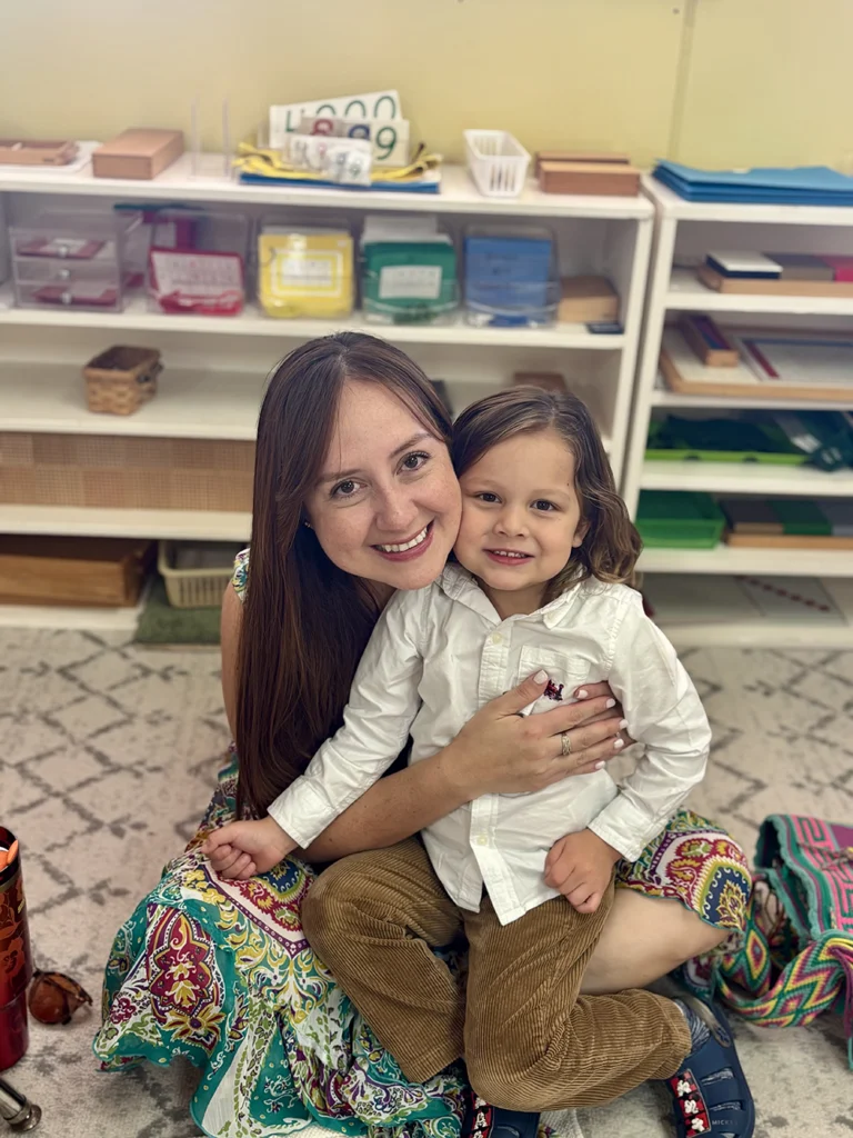 A mom with her child sitting on the floor mat smiling
