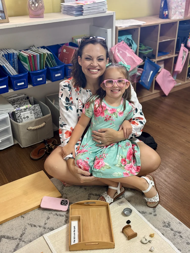 A mother and daughter in matching floral outfits posing for a photo