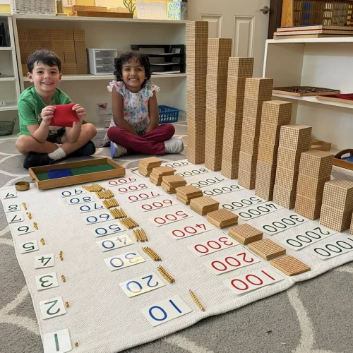 Two students working with Montessori math materials in the classroom